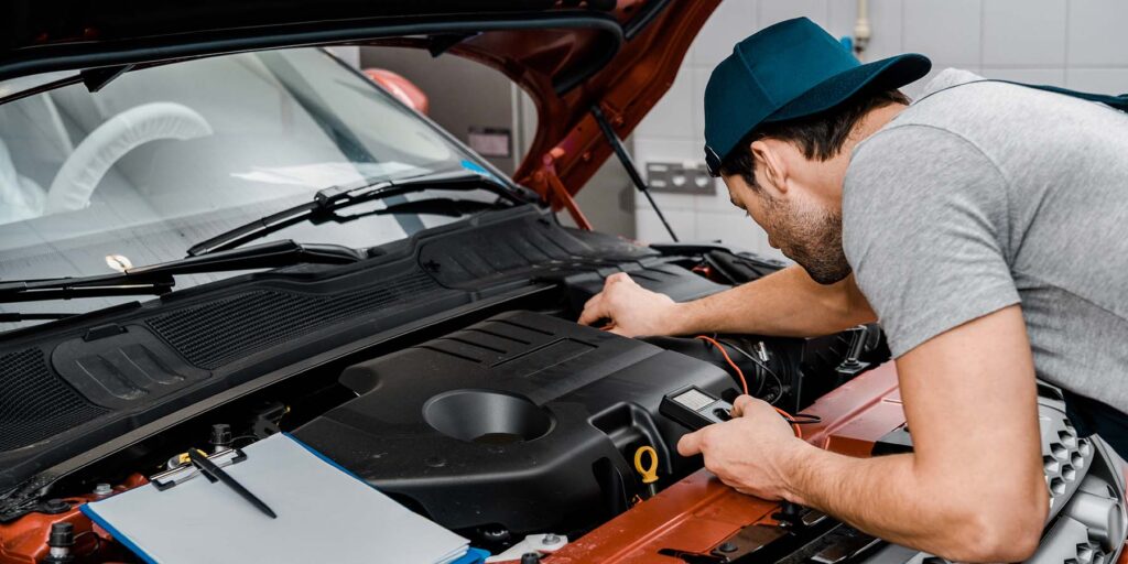 auto-mechanic-with-multimeter-voltmeter-checking-c-7MTRPJF.jpg